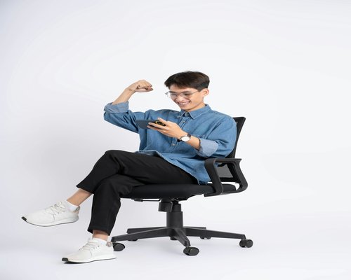 Man stretching arms while sitting in office chair